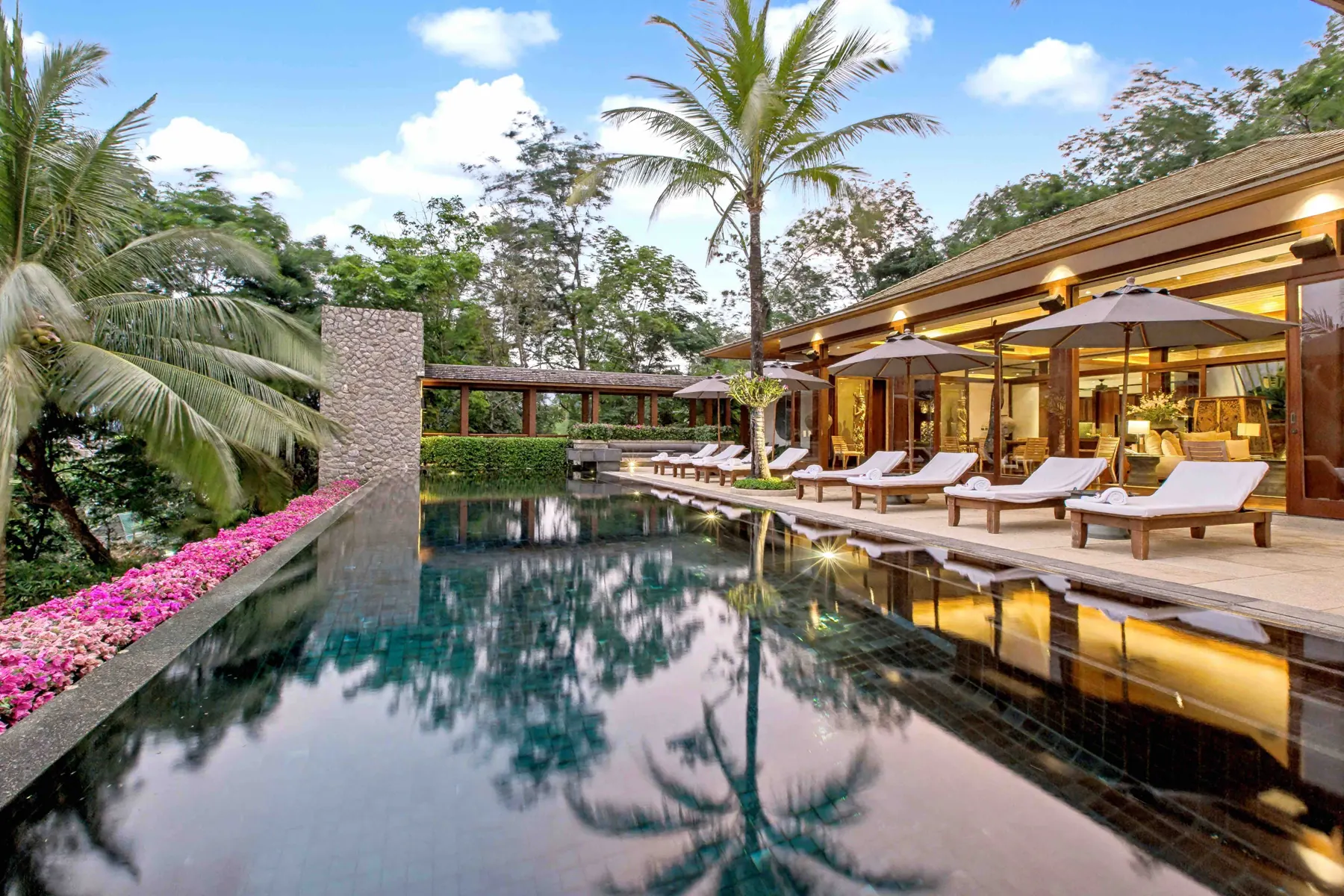 Infinity pool reflecting palms at dawn