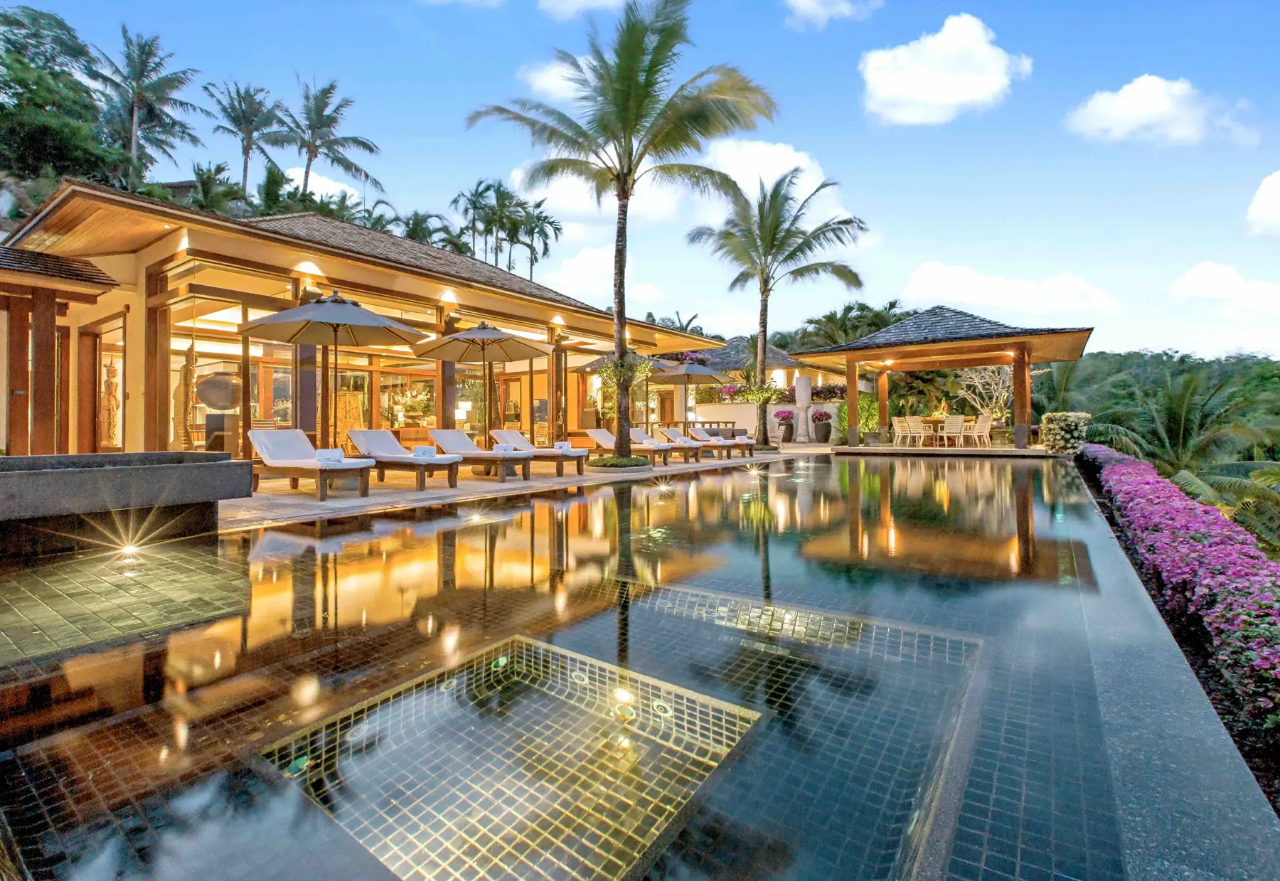 Infinity pool and pool terrace lit at dusk