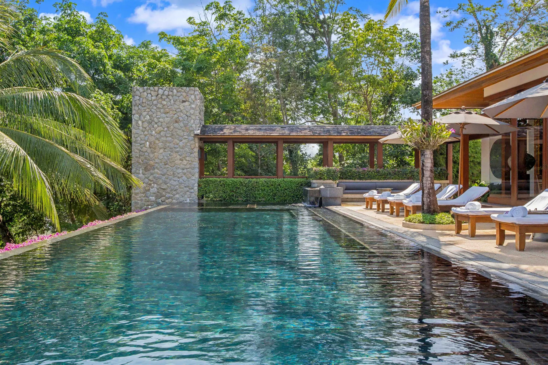 Infinity pool with natural stone wall and garden